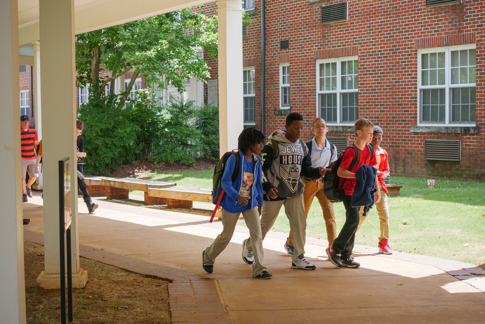 A group of students walking outside a school building. 