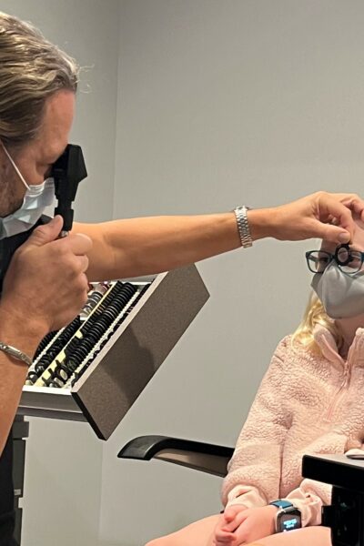 Doctor giving a vision exam to a young girl