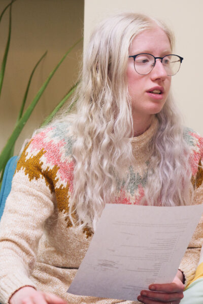 Student with glasses holding a paper