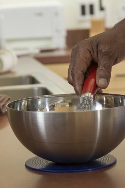 Person whisking in a bowl placed on a non-slip mat