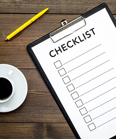 Blank checklist with space for ticks on a pad on an office desk.
