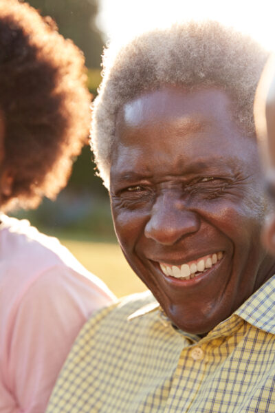 Smiling older person sits between two individuals