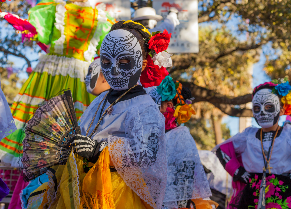 Person in sugar skull mask and costume for Dia de los Muertos (Day of the Dead) celebration