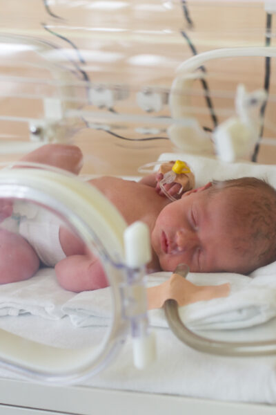 Premature newborn baby in the hospital incubator. Neonatal intensive care unit