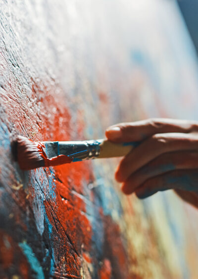 Close-up of person painting a vibrant, abstract painting