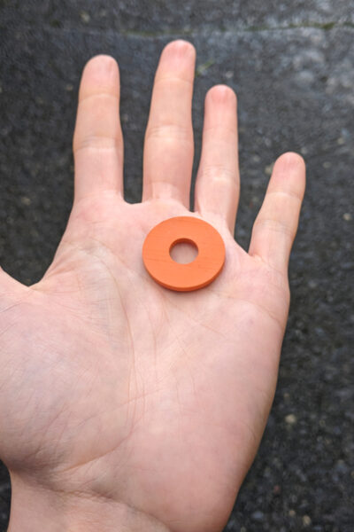Person holds rubber washer, a quarter-size circle