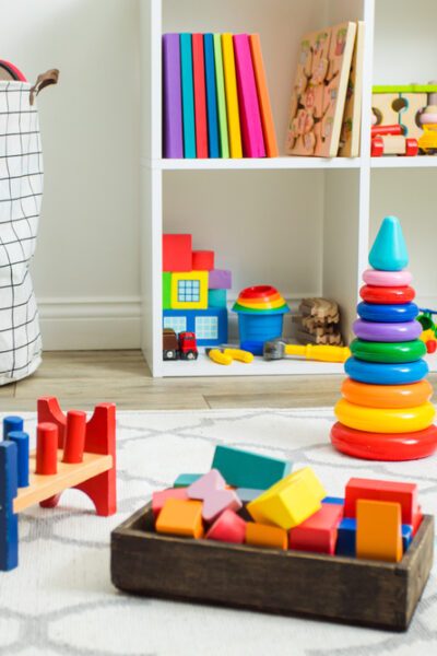 Colorful toys on white carpet in a children’s room. 