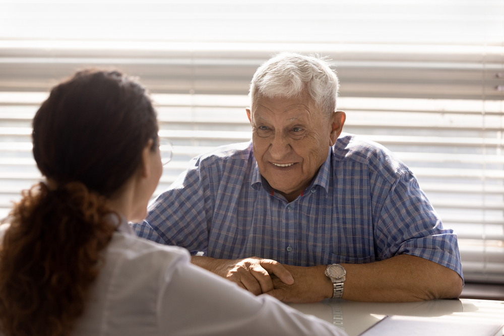 Older person talks with a professional at a table