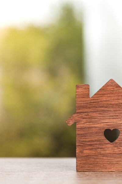 Close up horizontal shot of a silhouette in the shape of a house with a heart-shaped hole in the center.