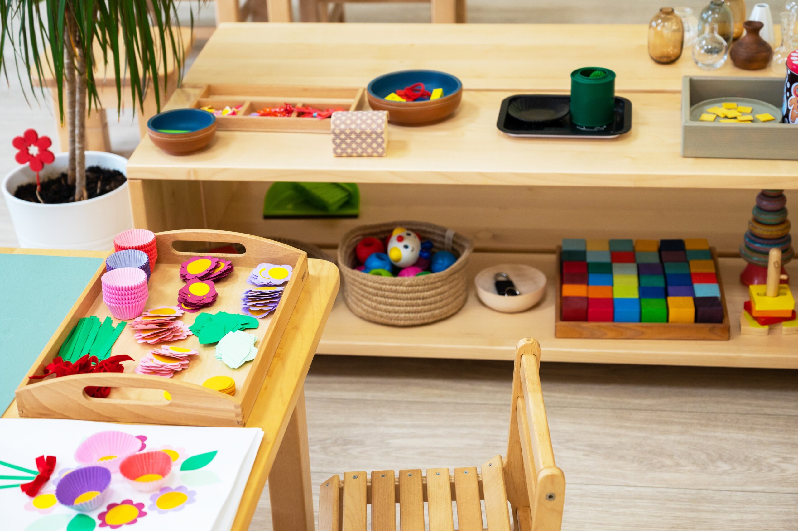 Preschool classroom with learning materials on a table and shelves.