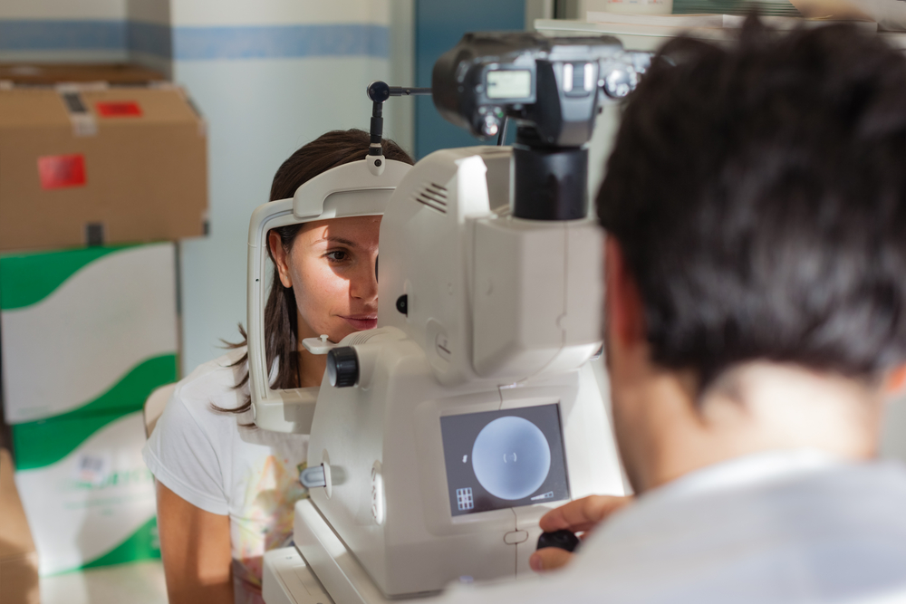 a young ophthalmologist using a non-mydriatic retinal camera on a young girl