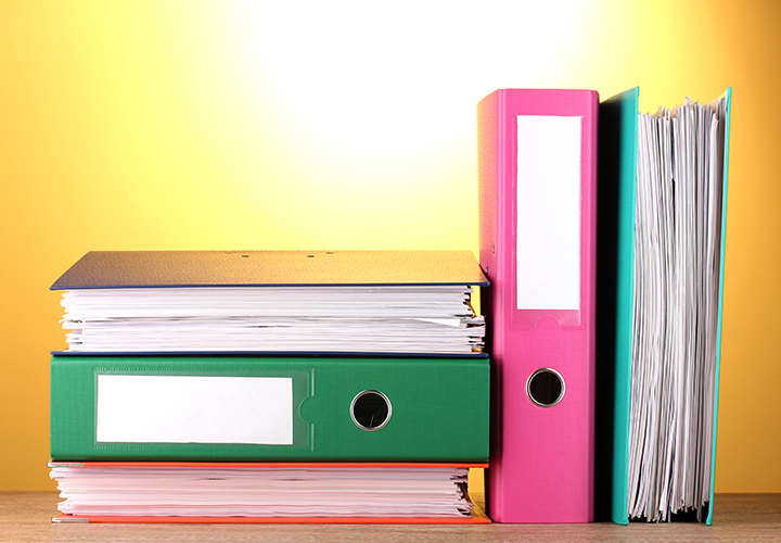Bright office binders on a wooden table on yellow background